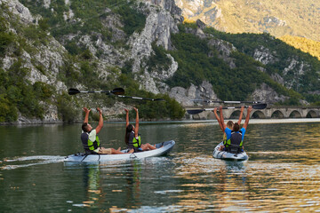 A group of friends enjoying having fun and kayaking while exploring the calm river, surrounding forest and large natural river canyons