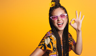 Summer vibes, shopping and discounts concept. Happy laughing girl in holiday outfit and sunglasses, shows zero, okay sign and looks positive, wears bright dress, isolated on yellow background