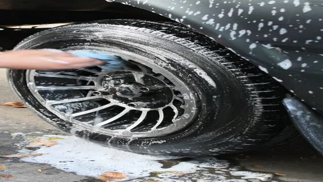 hands of a person washing an automobile tire