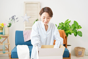 リビングで荷造りをする女性