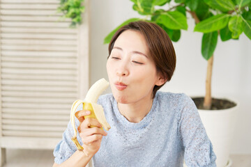 自宅で板ぽバナナを食べる女性