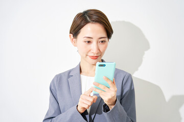 スマートフォンを笑顔で使うビジネスウーマン　白背景