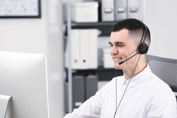 Hotline operator with headset working in office