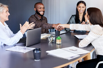 Congratulations, you are this months top employee. Shot of businesspeople shaking hands during a meeting in an office.