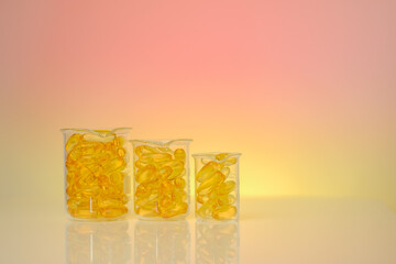 Fish oil capsules in transparent flasks . omega fatty acids oil capsules in containers on a pink background.Natural supplements and vitamin