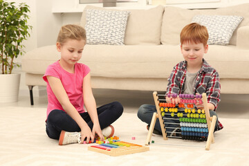 Children playing with different math game kits on floor in living room. Study mathematics with...