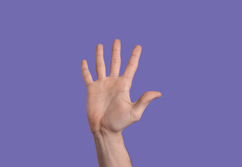 Man giving high five on purple background, closeup of hand