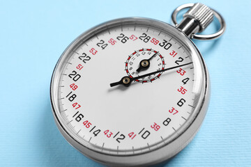 Vintage timer on light blue background, closeup. Measuring tool