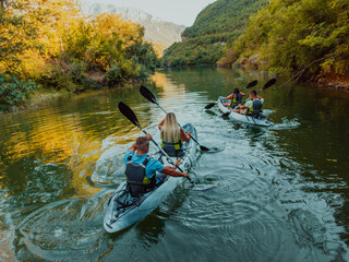 A group of friends enjoying having fun and kayaking while exploring the calm river, surrounding forest and large natural river canyons