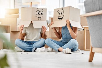 Silly times in abundance. Shot of a couple wearing boxes with smiley faces drawn on them on their heads while moving house.