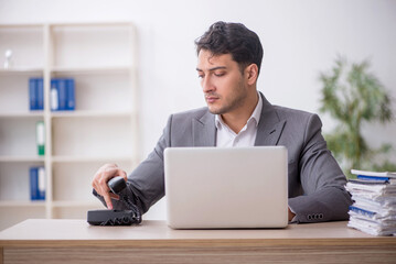 Young male employee and too much work in the office