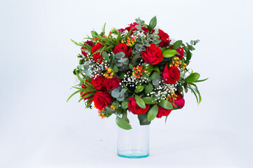 Many kinds of flowers placed in a brightly colored vase in a white setting