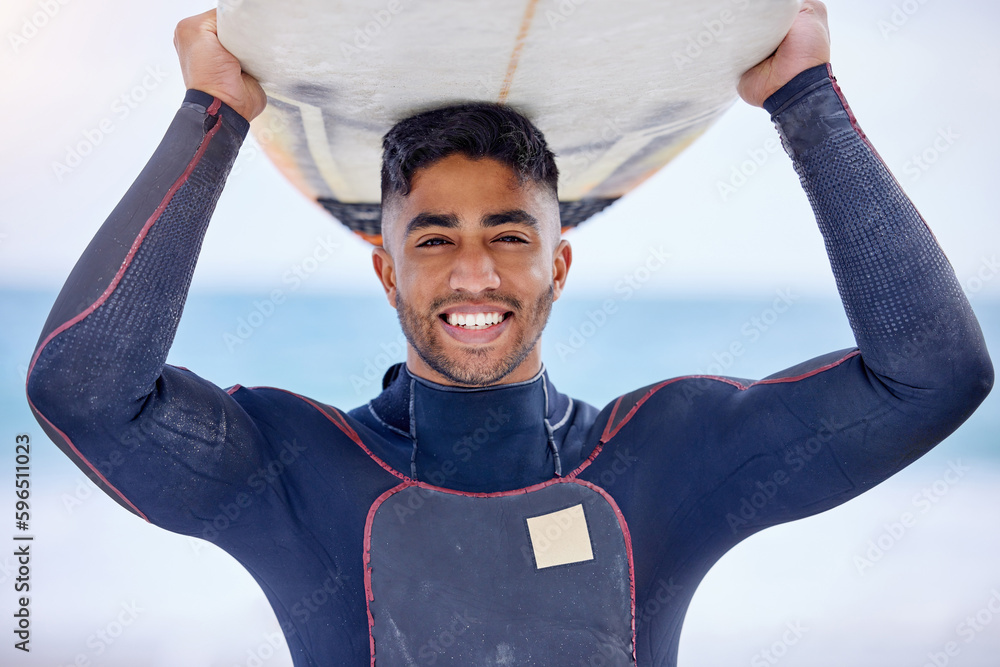 Sticker Surfing is my philosophy 101. Portrait of a handsome young man carrying a surfboard at the beach.