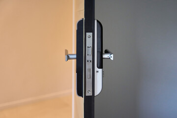 Part and detail of Digital door locking on black wood. Selective focus.