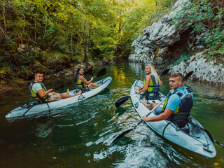 A group of friends enjoying having fun and kayaking while exploring the calm river, surrounding forest and large natural river canyons