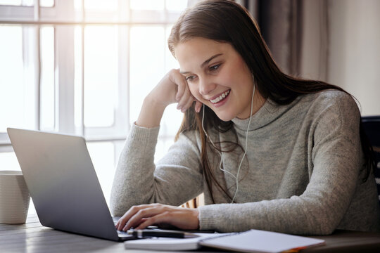 Hard workers deserves breaks too. Shot of a young businesswoman using a laptop while working from home.