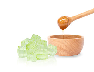Closeup honey dripping into wooden bowl with alovera cube gel isolated on white background, Skin...