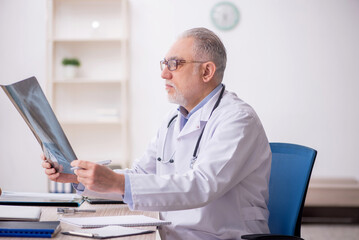 Old male doctor radiologist working at the hospital