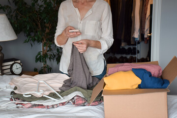 Woman is taking a picture of her unwanted clothing items to resale online