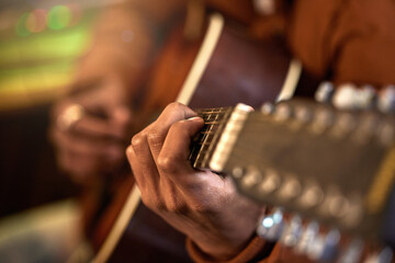 Fingers on the chords. Cropped shot of an unrecognizable male musician playing his guitar at home.