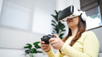 Young Asian woman wearing virtual reality touching air during the VR experience  Future technology concept.