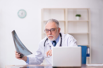 Old male doctor radiologist working in the clinic