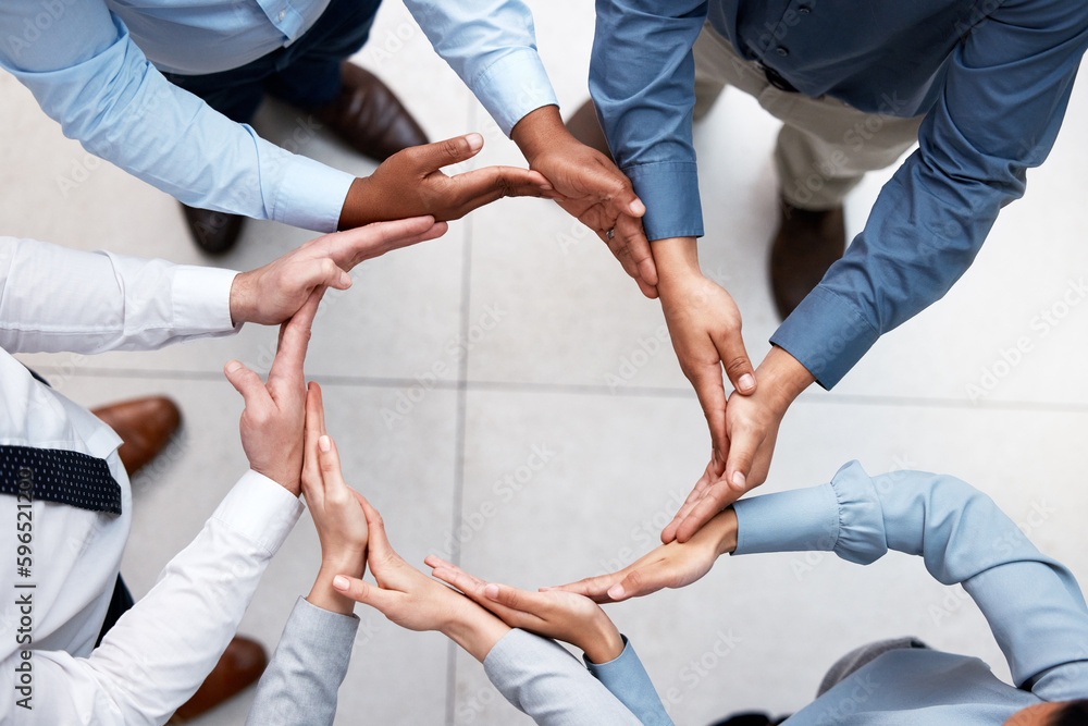 Poster round and round we go. shot of a group of unrecognizable businesspeople forming a circle with their 