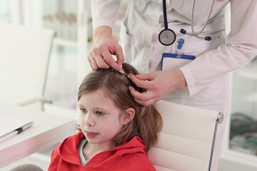 Therapist looks for insects in hair of little patient