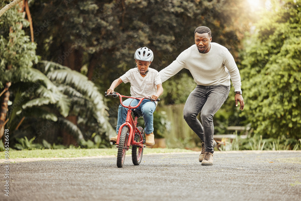 Poster You can do it. Shot of an adorable boy learning to ride a bicycle with his father outdoors.