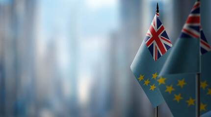 Small flags of the Tuvalu on an abstract blurry background