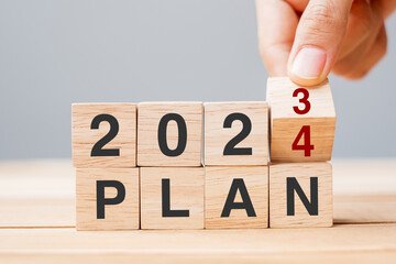 hand flipping block 2023 to 2024 PLAN text on table. Resolution, strategy, goal, motivation, reboot, business and New Year holiday concepts - obrazy, fototapety, plakaty