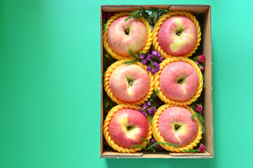 beautiful pink apple in the box on green background