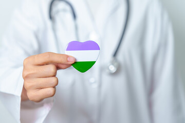 Queer Pride Day and LGBT pride month concept. Doctor hand holding purple, white and green heart shape with Stethoscope for Lesbian, Gay, Bisexual, Transgender, genderqueer and Pansexual community