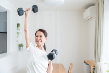 ダンベルで筋トレする健康なシニア女性