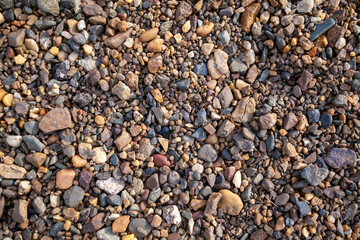 Crushed stone on the seashore. Selective focus on object. The stones were laid on the ground in the garden as a background. Background blur. Pebble stones background.