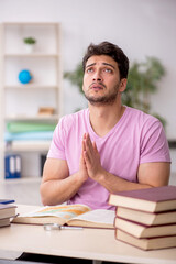 Young male student sitting in the classroom