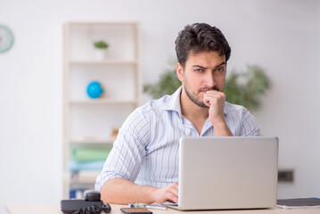 Young male employee working in the office