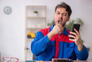 Young male repairman repairing computer