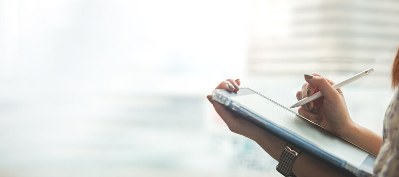 Digital signature, electronic note taking. Close up view of woman holding stylus pen signing electronic documents via digital application in tablet