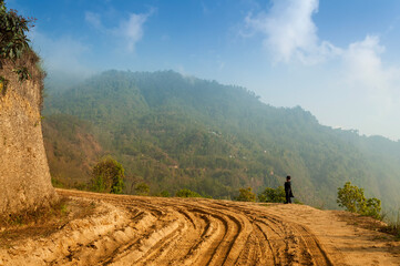 Sikkim, India - 22nd March 2004 : A school boy in uniform, waiting for his school bus in morning,...
