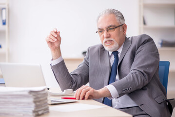 Old male employee working in the office