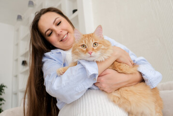 young pregnant woman at home with her red cat. Pet owner at home,