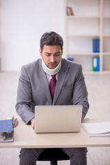 Young male employee after car accident sitting in the office