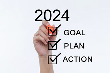 Women's hands write goals for the year, hand holding a felt pen with 2024 Goal. Plan and Action Checklist concept. Businessman pressing 2024 start up business.