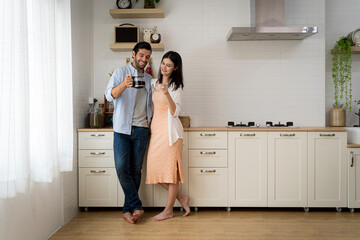 Happy couple drinking coffee and making plans for the day while enjoying each other. Romantic concept. Beautiful couple drinking coffee or tea on the modern terrace in mountains.