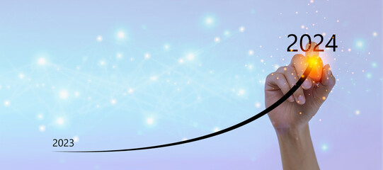 Businessman hand drawing line for increasing arrow from 2023 to 2024 for preparation merry...