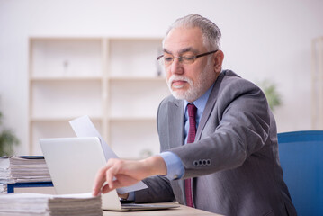 Old male employee working in the office