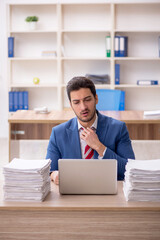 Young male employee and too much work in the office