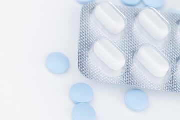 White blister pack pills, pharmaceutical product, many blue pills separately on a white background,...