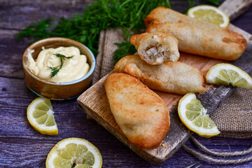   Allasca Pollock Fish  Bites in a crispy Tempura  Batter.Fish and chips .Close up of   crispy breaded  deep fried fish fingers with breadcrumbs s erved with remoulade sauce and  lemon